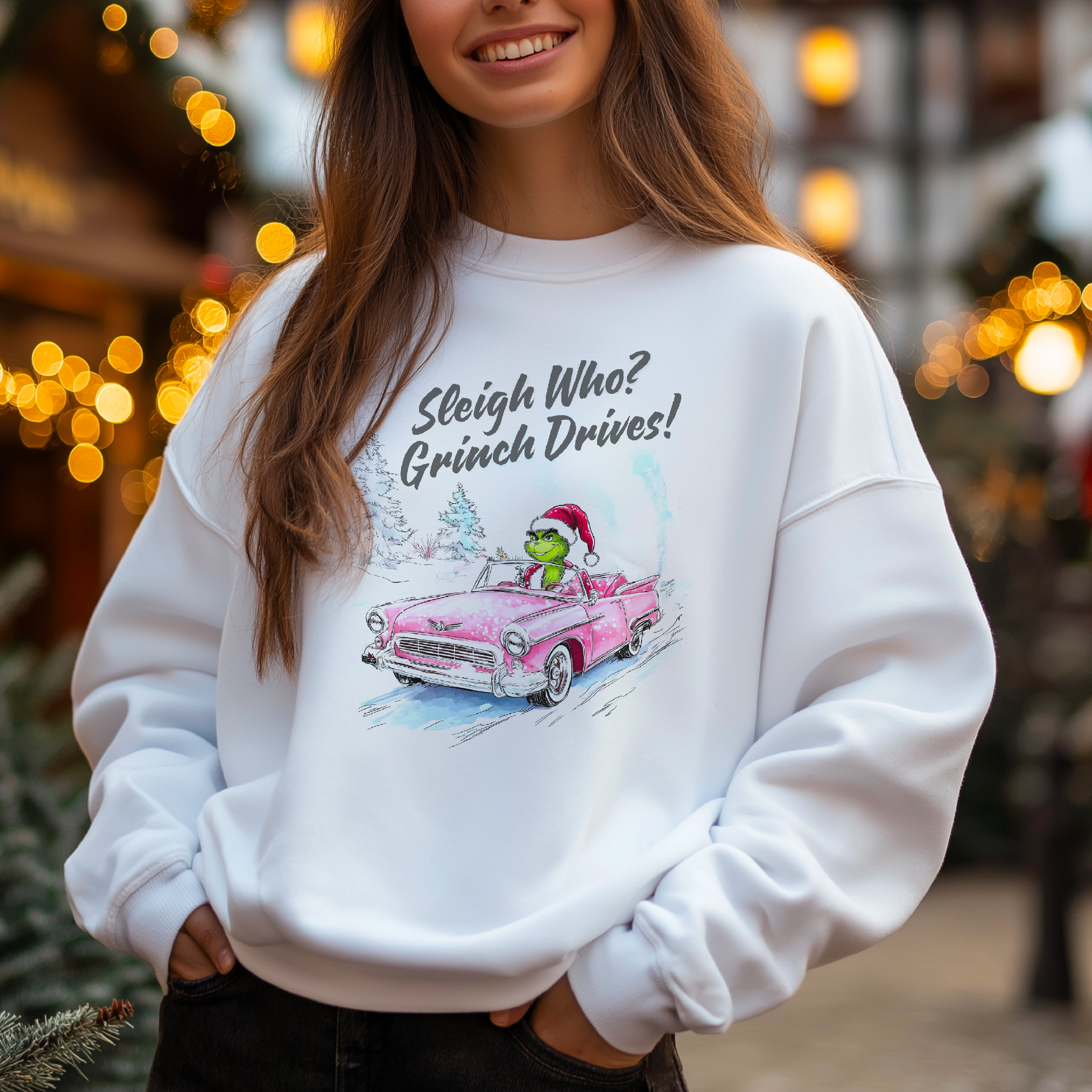 A person wearing a white sweatshirt with a design of the Grinch character from Dr. Seuss' books, driving a red sleigh, with Christmas-themed decorations in the background.