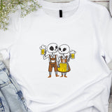 White t-shirt with cartoon skeletons holding beer mugs on a wooden surface.